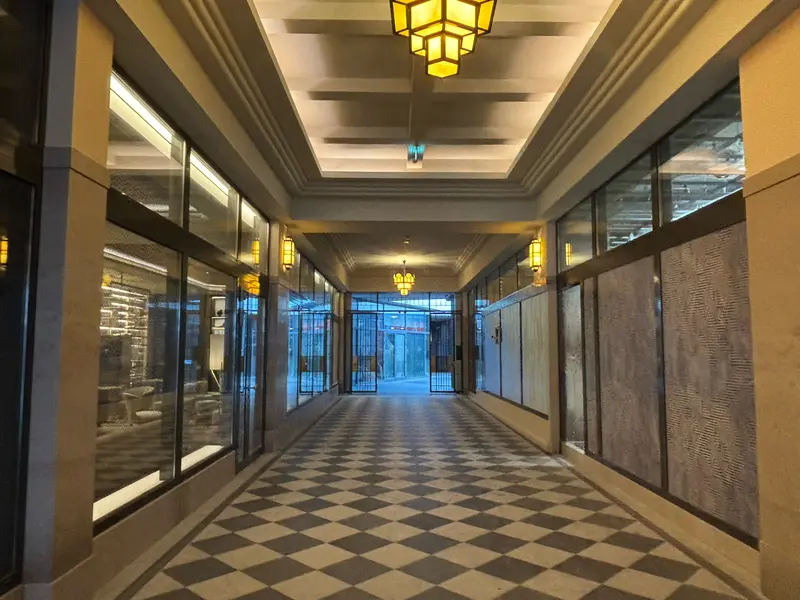 Passage couvert du Plaza Liberty au sol en damier, éclairé par des lustres